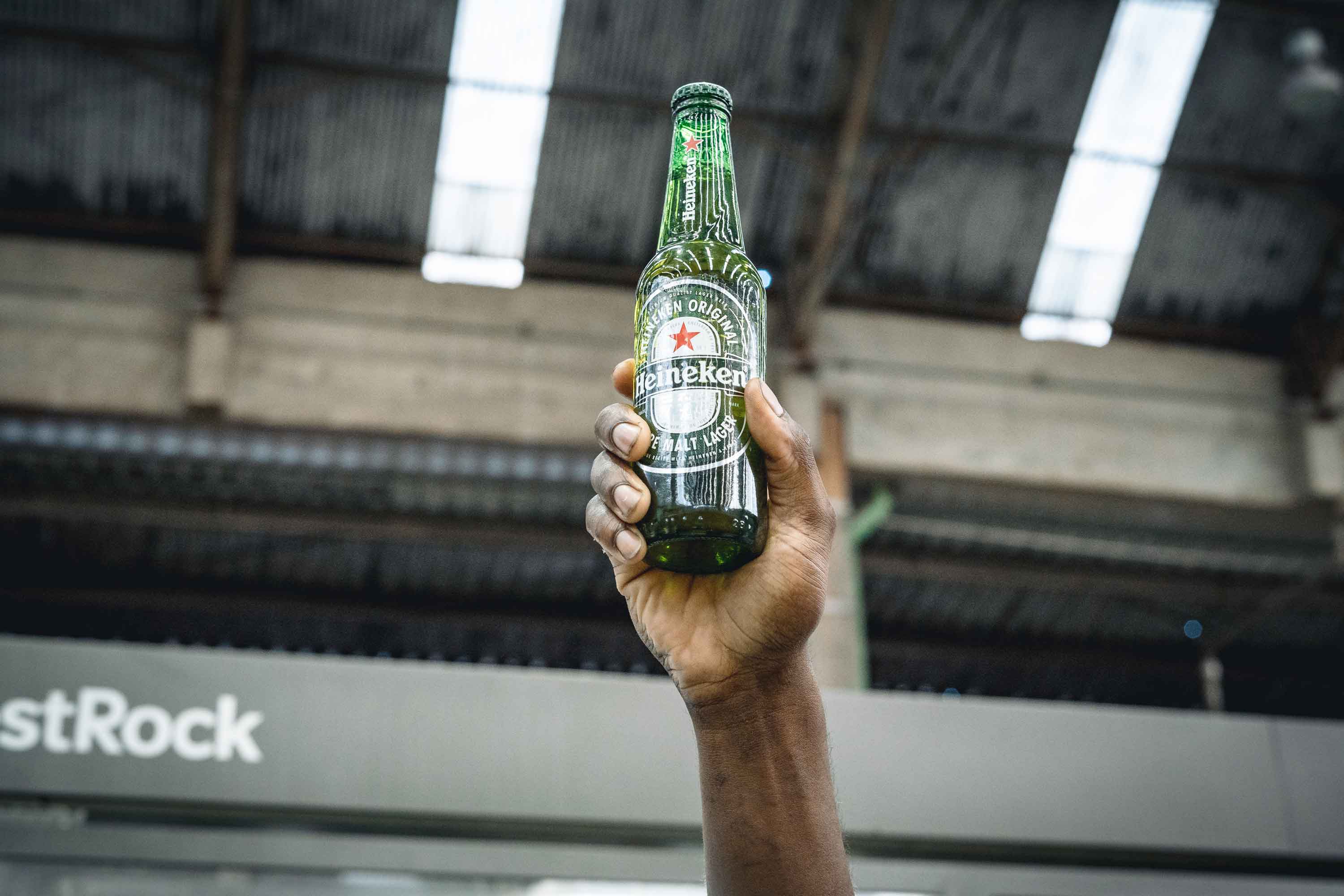 Mão segurando uma Heineken
