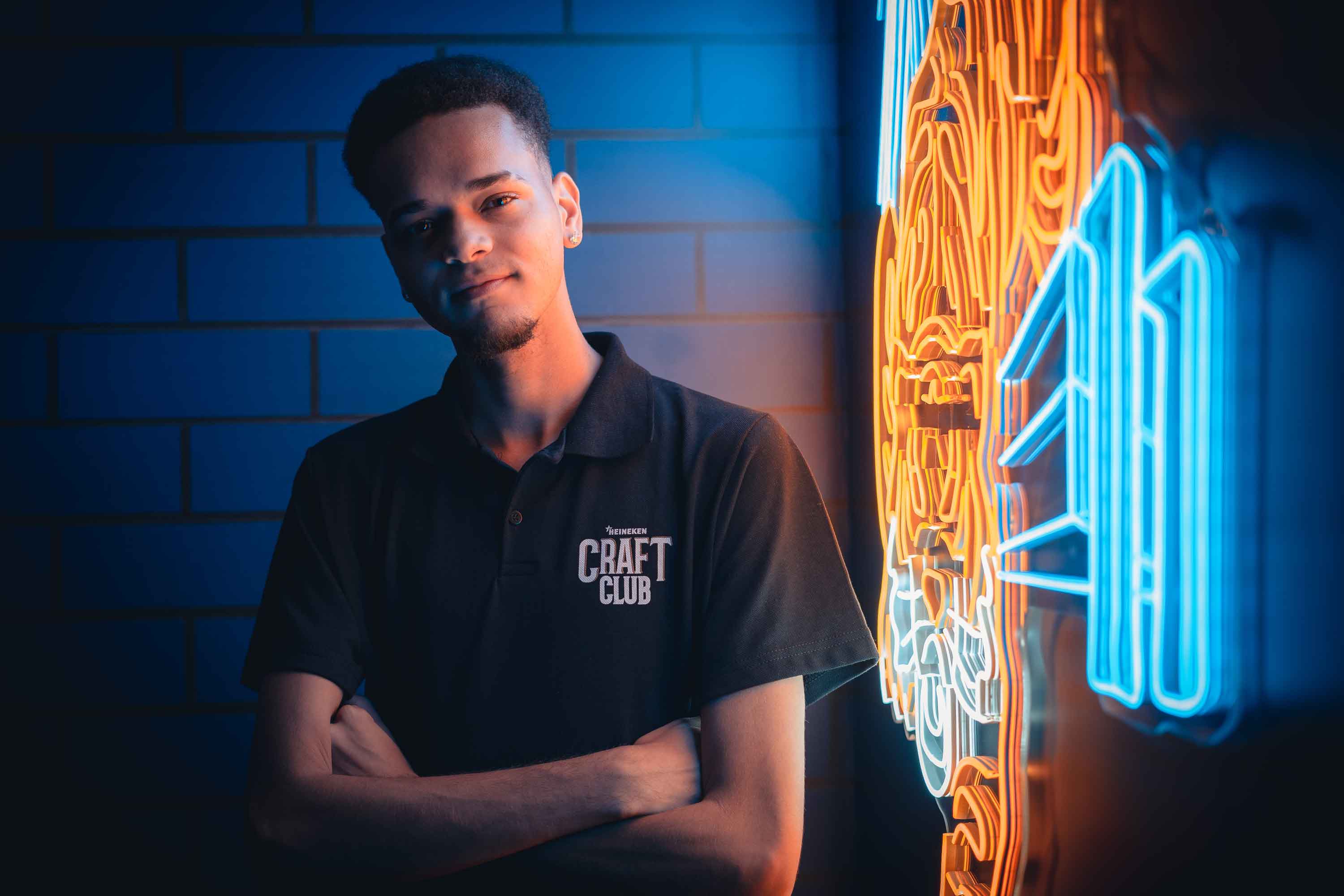 Jovem encostado em  uma parede de led